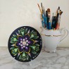 Transparent CD holder displaying a painted CD on a table